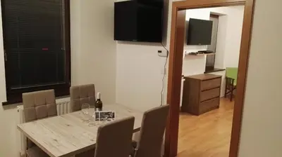 a dining room with a table with chairs and a television at Gorenjka in Kranjska Gora
