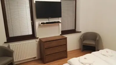 a room with a tv and a bed and two chairs at Gorenjka in Kranjska Gora