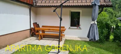 a bench and an umbrella on a patio at Gorenjka in Kranjska Gora