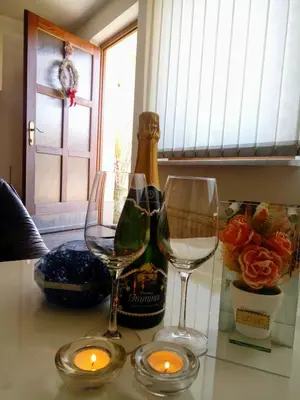a table with two wine glasses and candles on it at Dolenjska vila with Private Sauna in Žužemberk