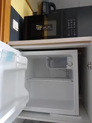 an open refrigerator with a black microwave in it at Dolenjska vila with Private Sauna in Žužemberk