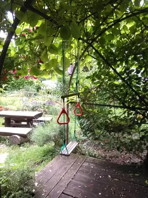 a swing hanging from a tree in a garden at Apartments Kapus Center in Bled