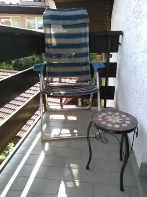 a rocking chair and a stool sitting on a porch at Apartments Kapus Center in Bled