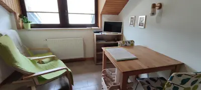 a small room with a wooden table and chairs at Apartments Kapus Center in Bled