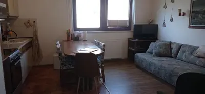 a living room with a table and a couch at Apartments Kapus Center in Bled
