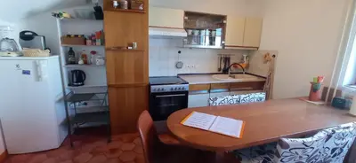 a small kitchen with a wooden table and a sink at Apartments Kapus Center in Bled