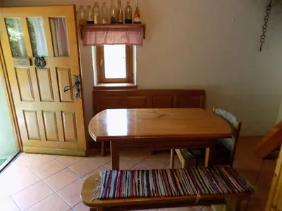 a table and a bench in a room with a door at Holiday Home Na planini in Tolmin