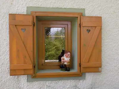 a toy doll is sitting in a window at Holiday Home Na planini in Tolmin