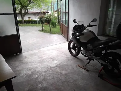 a motorcycle parked in a garage next to a door at Apartment Gaja in Tolmin