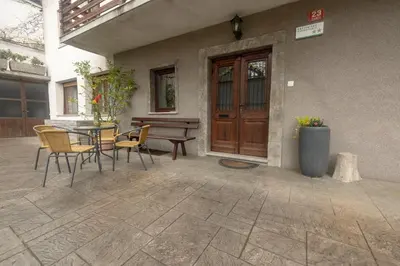 a patio with a table and chairs and a wooden door at Apartment Gaja in Tolmin