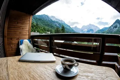 a cup of coffee sitting on a table with a laptop at A Million Dollar View in Kranjska Gora