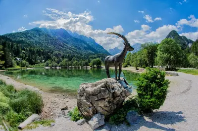 a statue of a goat on a rock next to a river at A Million Dollar View in Kranjska Gora