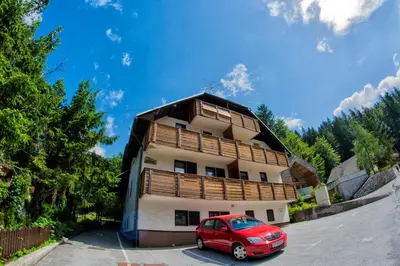 a red car parked in front of a building at A Million Dollar View in Kranjska Gora