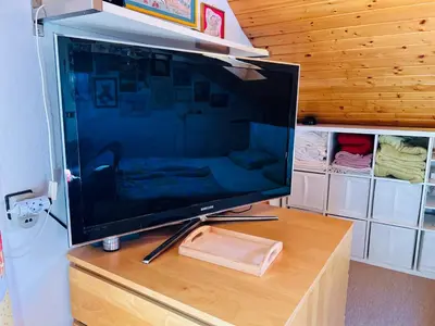 a large flat screen tv sitting on top of a wooden table at House for nature lovers in Medvode