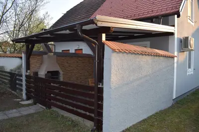 a wooden pergola on the side of a house at Borovnica Čatež in Čatež ob Savi