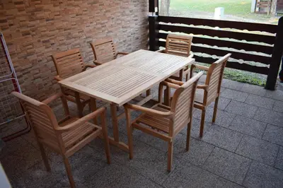 a wooden table and chairs on a patio at Borovnica Čatež in Čatež ob Savi