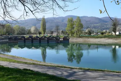 a body of water with a bridge in a park at Borovnica Čatež in Čatež ob Savi