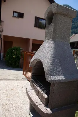 a stone pizza oven sitting outside of a building at Apartma Lesjak 1 in Bovec