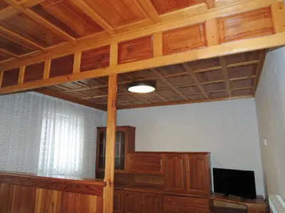 a room with a wooden ceiling and a tv at Apartma Lesjak 1 in Bovec