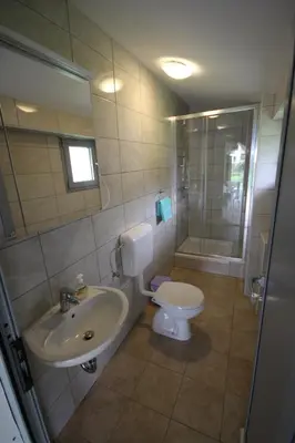 a bathroom with a toilet and a sink and a shower at Lesjakova Domačija in Bovec