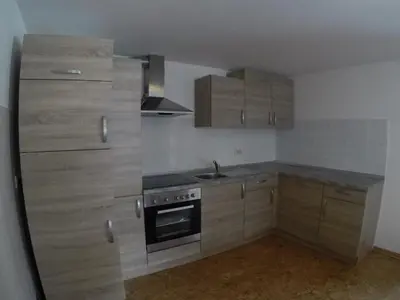 a small kitchen with wooden cabinets and a stove at Lesjakova Domačija in Bovec
