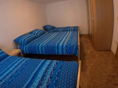 two beds in a room with blue comforter at Lesjakova Domačija in Bovec