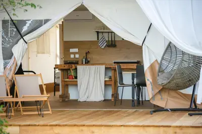 a tent on a deck with a table and chairs at Glamping Kolpa Resort in Gradac