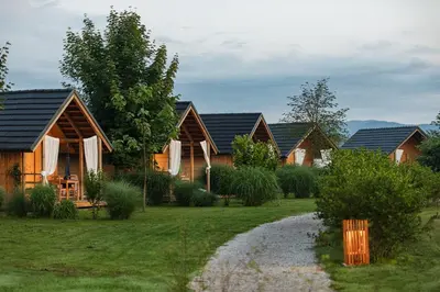 a row of wooden houses in a yard at Glamping Kolpa Resort in Gradac