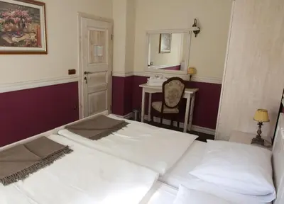 a bedroom with two beds and a table and a mirror at Turistična kmetija Weiss in Miklavž pri Taboru