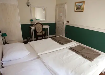 two beds in a room with a mirror and a table at Turistična kmetija Weiss in Miklavž pri Taboru