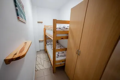 a small room with a bunk bed and a closet at Apartma Kamp Ajdovščina in Ajdovščina