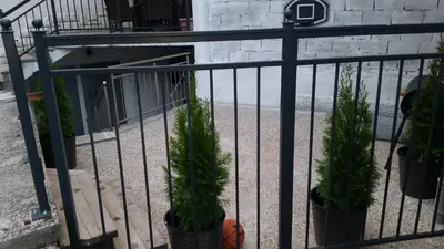 a fence with potted plants in front of a building at Apartma Trebušca in Dolenja Trebuša