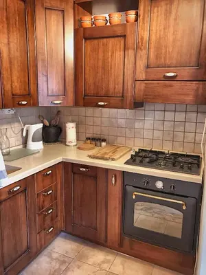 a kitchen with wooden cabinets and a stove top oven at Predel House in Log pod Mangartom