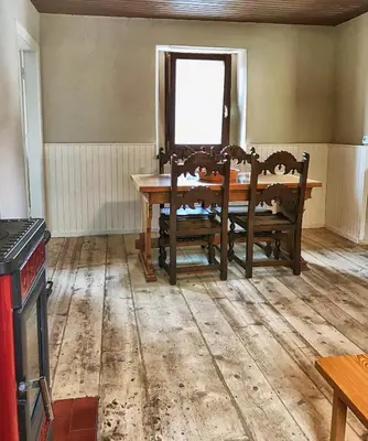 a dining room with a wooden table and chairs at Predel House in Log pod Mangartom