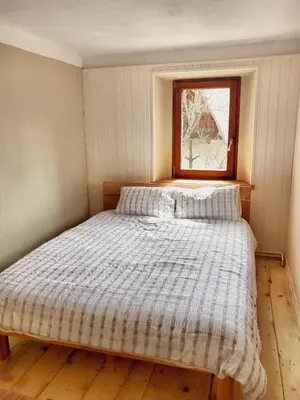 a bed in a small room with a window at Predel House in Log pod Mangartom