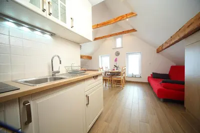 a kitchen with a sink and a red couch at Apartments Planica in Kranjska Gora