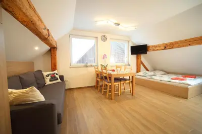 a living room with a couch and a table and a bed at Apartments Planica in Kranjska Gora