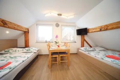 a room with two beds and a table with a chair at Apartments Planica in Kranjska Gora