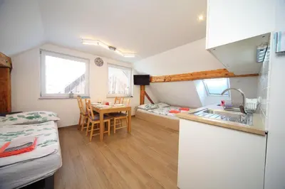 a kitchen with a sink and a table in a room at Apartments Planica in Kranjska Gora