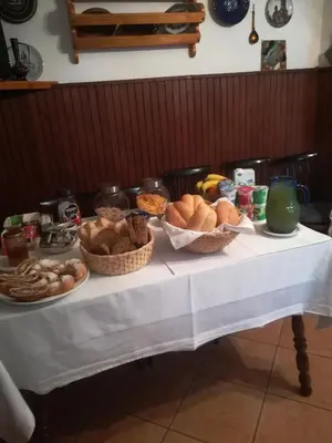 a table topped with baskets of bread and other foods at Apartments and rooms Cerkovnik in Bohinj