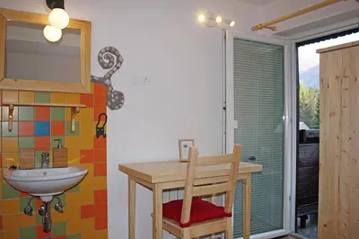 a bathroom with a sink and a table and a mirror at Apartments and rooms Cerkovnik in Bohinj