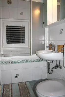 a bathroom with a sink and a toilet and a window at Apartments and rooms Cerkovnik in Bohinj