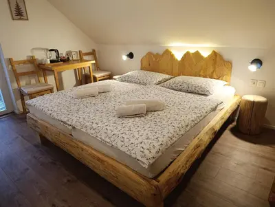 a large wooden bed with two pillows on it at Apartments and rooms Cerkovnik in Bohinj