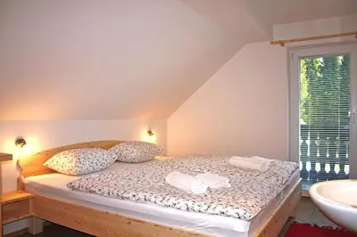 a bedroom with a bed with two pillows and a window at Apartments and rooms Cerkovnik in Bohinj