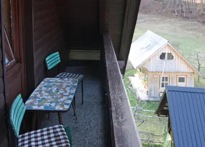 a porch with a table and chairs and a house at Apartments and rooms Cerkovnik in Bohinj