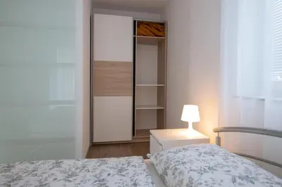 a bedroom with a closet with a bed and a lamp at Sobe Meta in Brezje