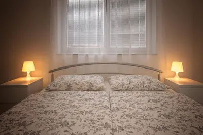 a bedroom with a bed with two lamps on it at Sobe Meta in Brezje