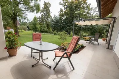 a patio with a white table and two chairs at Sobe Meta in Brezje