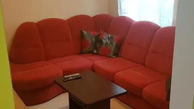 a red couch in a living room with a table at Apartma Pr Maruši in Bovec