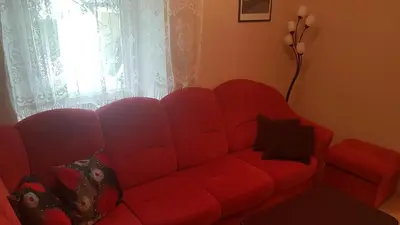 a red couch in a living room with a window at Apartma Pr Maruši in Bovec